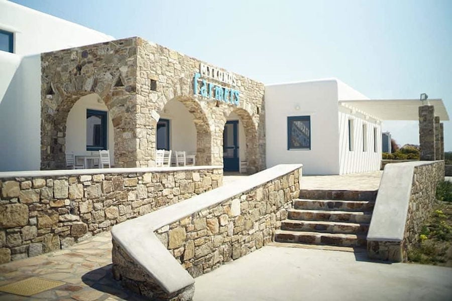 one side of stone building that says 'MYKONOS farmers' in upper part of the entrance